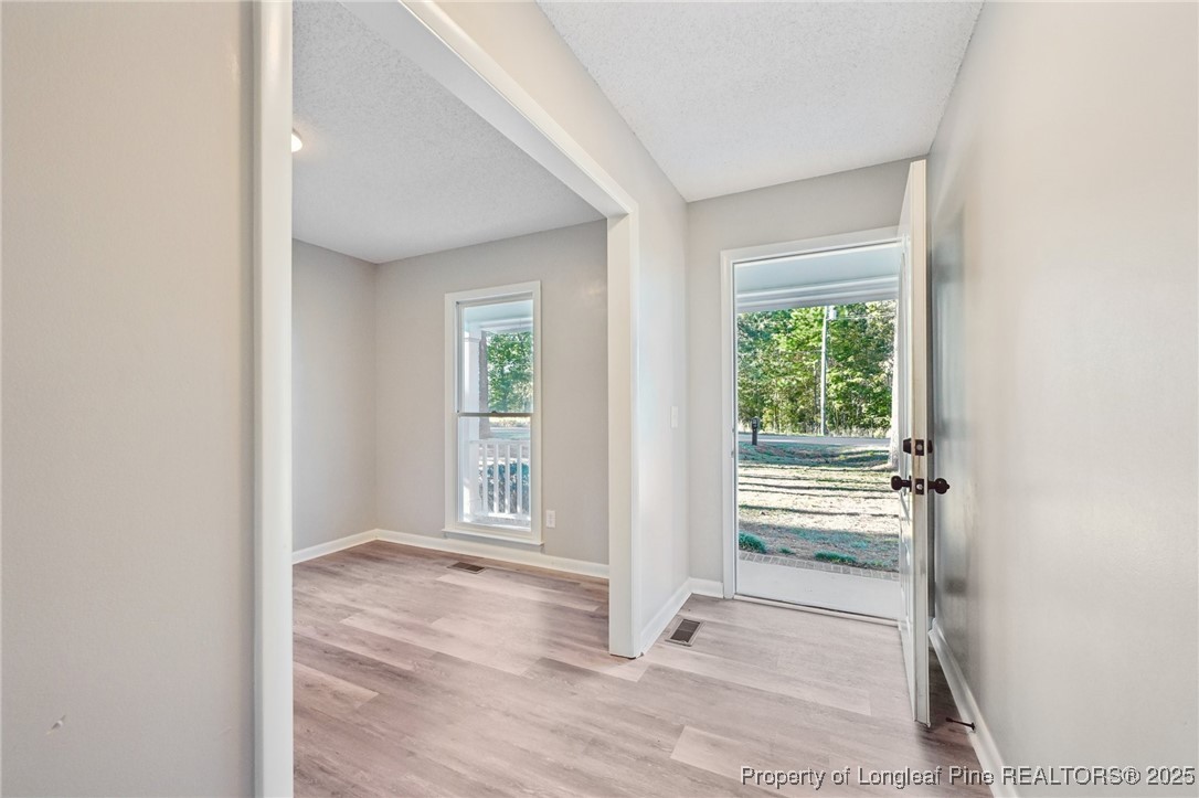211 Lemuel Black Road Bunnlevel, NC 28323 - Photo 9 of 29 an empty room with wooden floor and windows