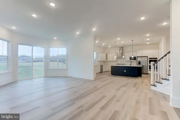 an empty room with wooden floor and window