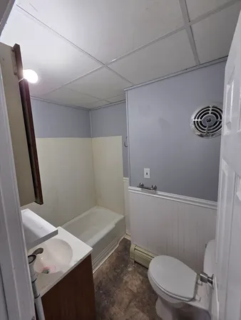 a bathroom with a sink a toilet and shower
