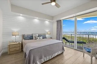 a bedroom with a balcony a bed and a night stand