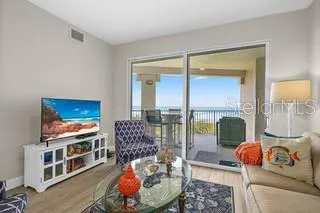 a living room with furniture a flat screen tv and a floor to ceiling window