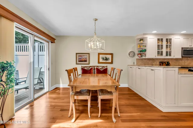 a dining room with furniture a chandelier and wooden floor