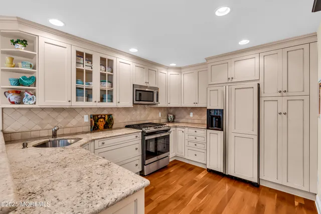a kitchen with granite countertop white cabinets and white appliances