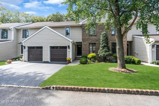 a front view of a house with a garden and plants