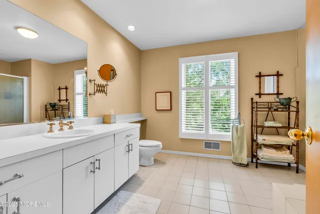 a spacious bathroom with a double vanity sink a mirror and a bathtub