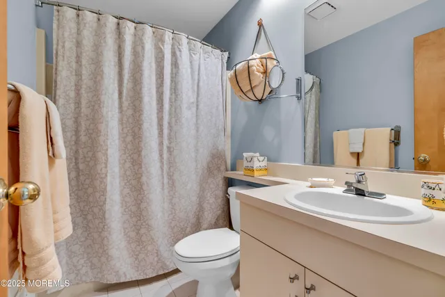 a bathroom with a sink a toilet and shower curtain