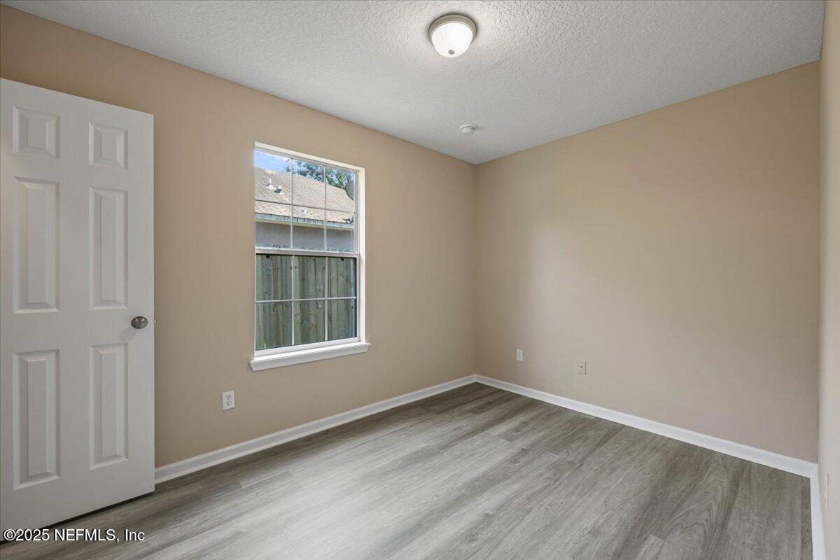 4527 Clairmont Road Jacksonville, FL 32207 - Photo 19 of 31 an empty room with wooden floor and windows