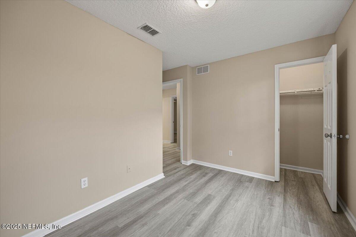 4527 Clairmont Road Jacksonville, FL 32207 - Photo 21 of 31 a view of an empty room with wooden floor and a ceiling fan