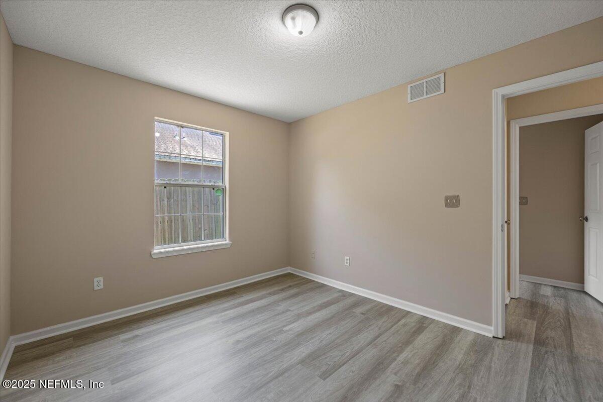 4527 Clairmont Road Jacksonville, FL 32207 - Photo 23 of 31 an empty room with wooden floor and windows
