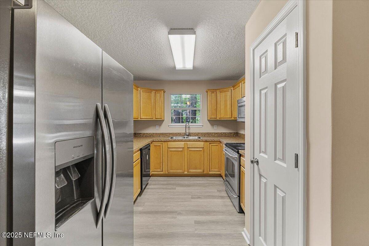 4527 Clairmont Road Jacksonville, FL 32207 - Photo 9 of 31 a kitchen with stainless steel appliances granite countertop a refrigerator a stove and a sink with large window
