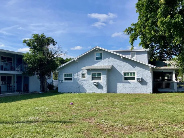 a front view of house with yard and trees in the background