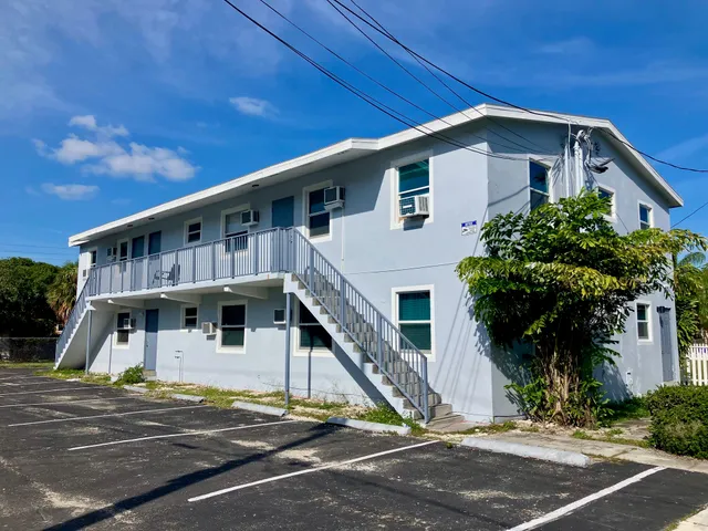 a front view of a house with a tree
