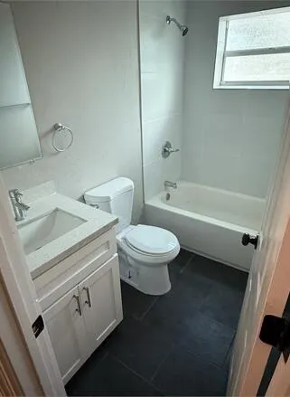 a white toilet sitting next to a bath tub