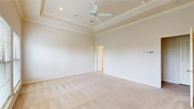 an empty room with windows and fan