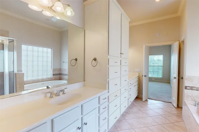 a spacious bathroom with a shower sink and mirror