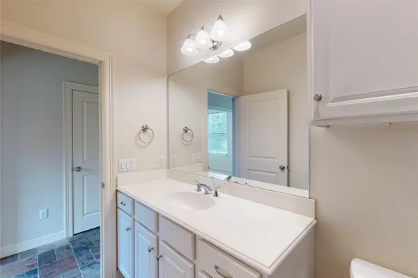 a bathroom with a sink vanity granite and a mirror