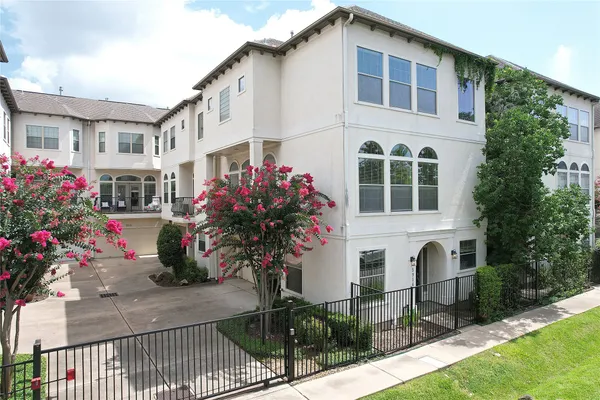 a front view of a house with a yard and potted plants