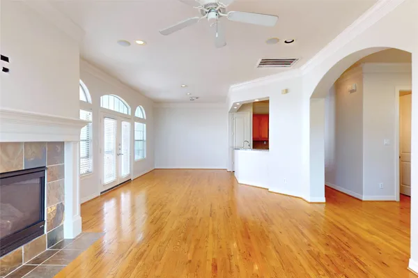 a view of an empty room with window and wooden floor