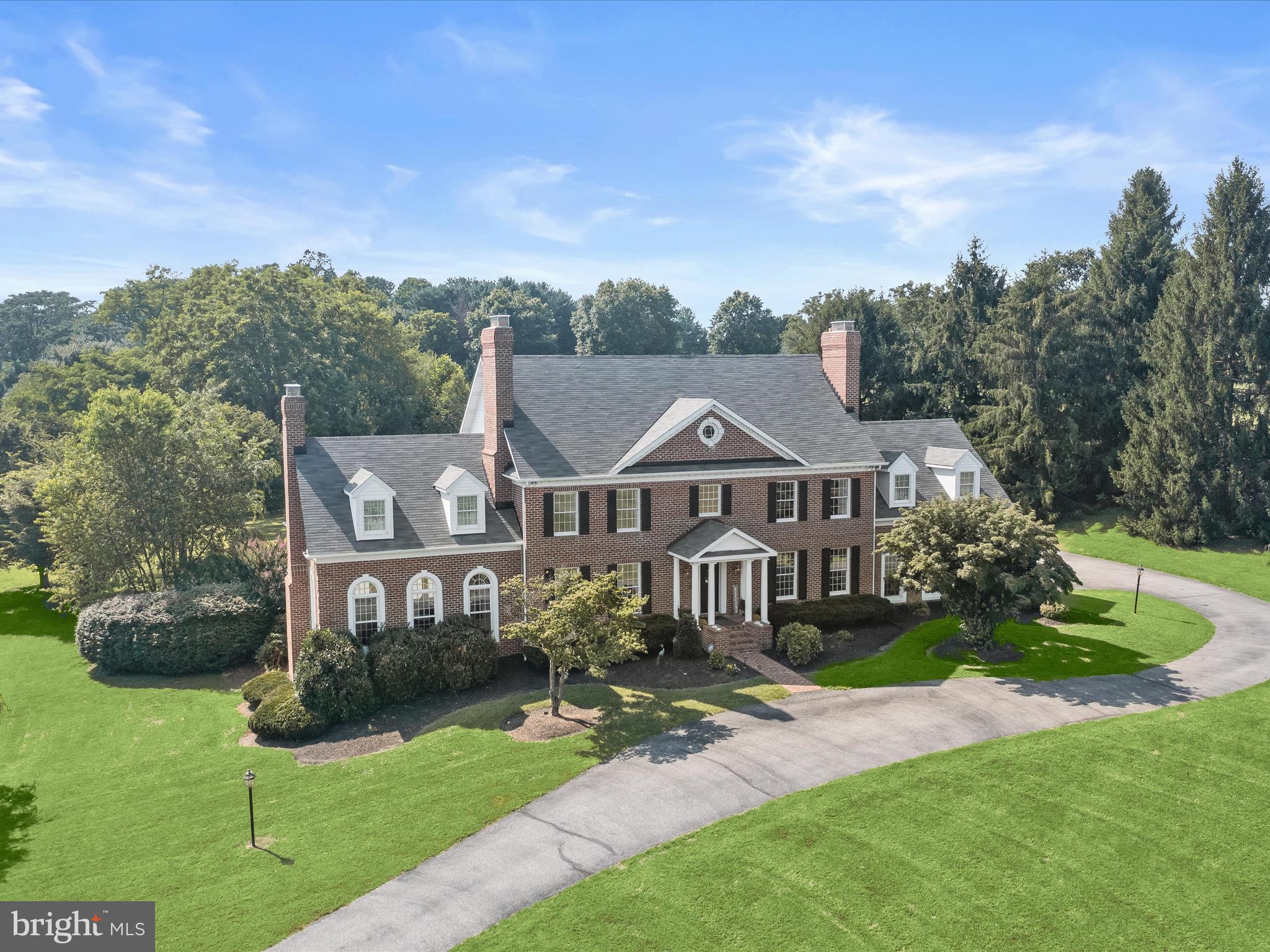a front view of a house with yard and green space