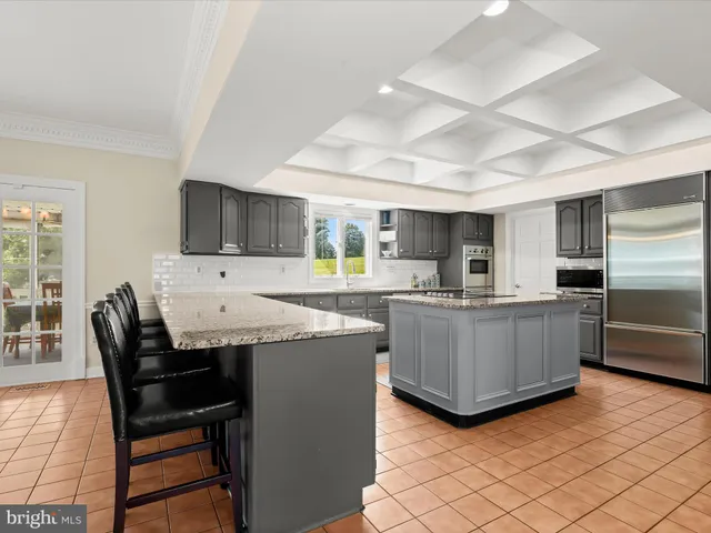 an empty room with wooden floor cabinet and windows