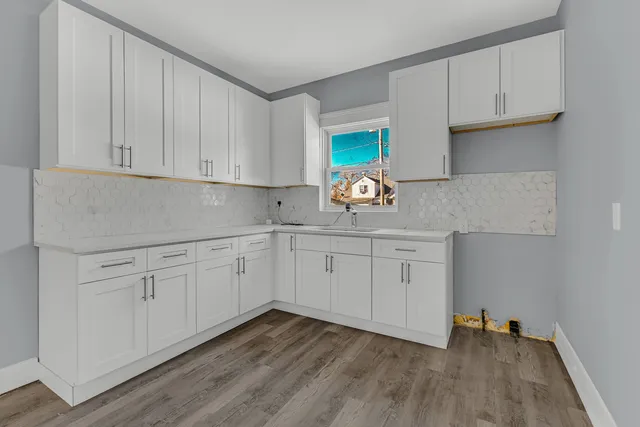 a kitchen with granite countertop white cabinets and a sink