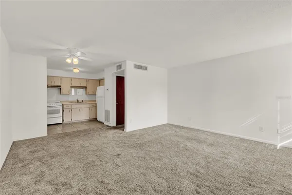 a view of a kitchen with refrigerator and white cabinets