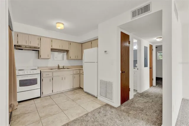 a kitchen with white cabinets and white appliances