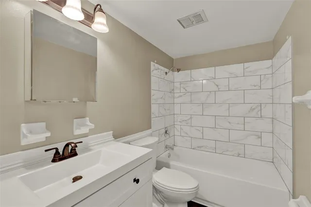 a bathroom with a bathtub shower sink vanity and toilet