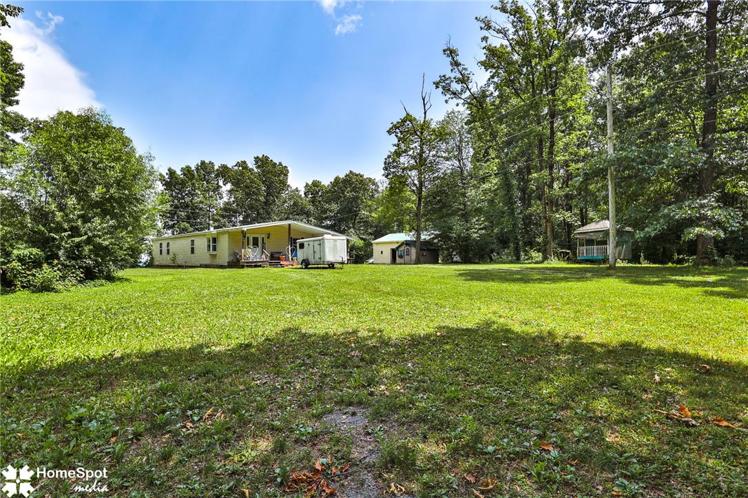 3795 Rhoades Road Kempton, PA 19529 - Photo 39 of 42 A spacious, verdant yard unfolds before a charming residence, surrounded by mature trees.