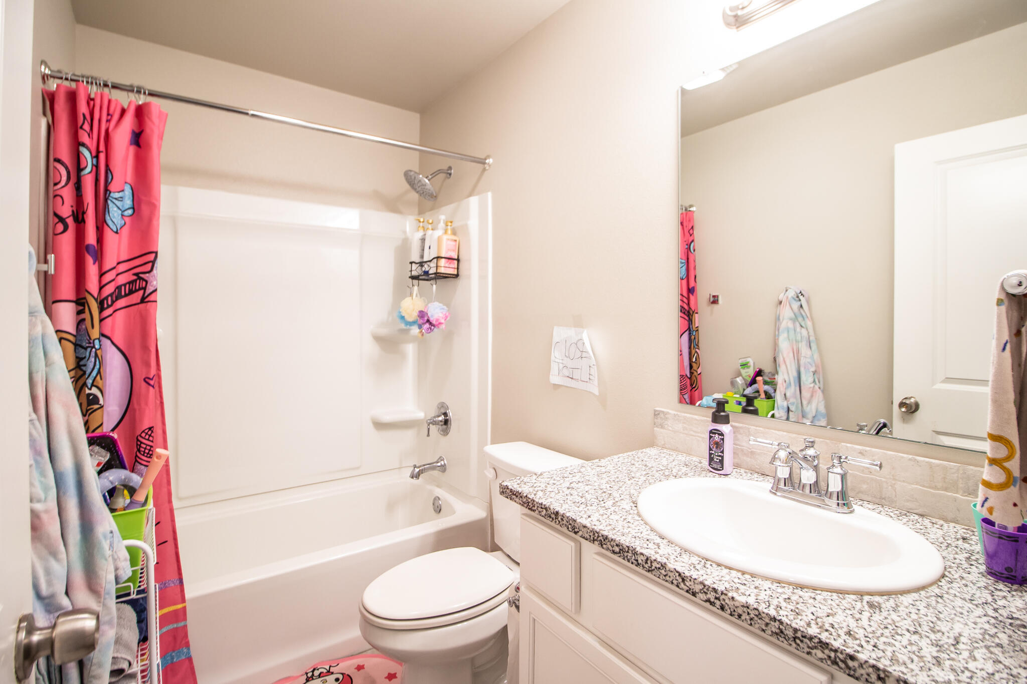 2908 Waverly Avenue Lubbock, TX 79407 - Photo 17 of 22 a bathroom with a granite countertop sink a toilet and shower