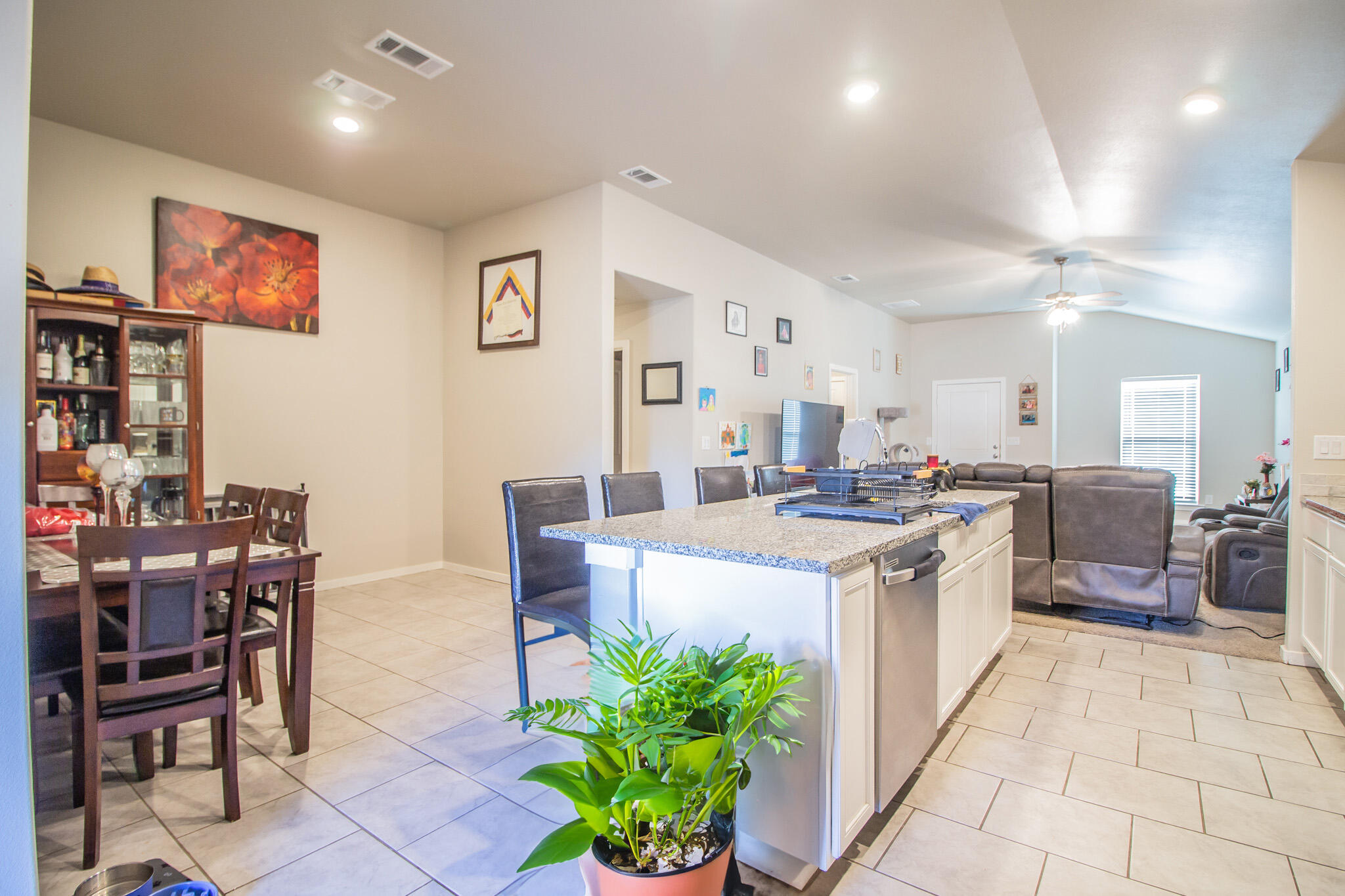 2908 Waverly Avenue Lubbock, TX 79407 - Photo 8 of 22 a kitchen with stainless steel appliances kitchen island granite countertop a table chairs and a refrigerator