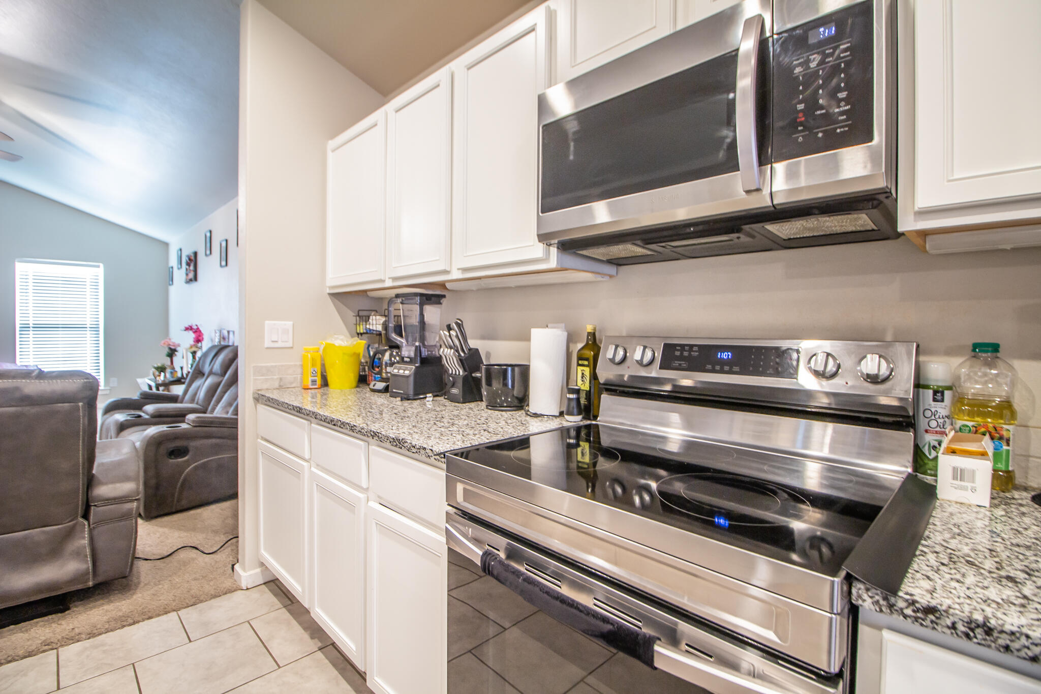2908 Waverly Avenue Lubbock, TX 79407 - Photo 9 of 22 a kitchen with stainless steel appliances kitchen island granite countertop a stove and a microwave