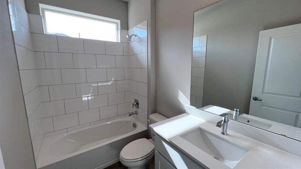 153 Medina Lane Rhome, TX 76078 - Photo 9 of 21 a bathroom with a bathtub shower sink vanity mirror and toilet