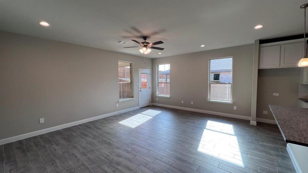 153 Medina Lane Rhome, TX 76078 - Photo 4 of 21 an empty room with wooden floor and windows