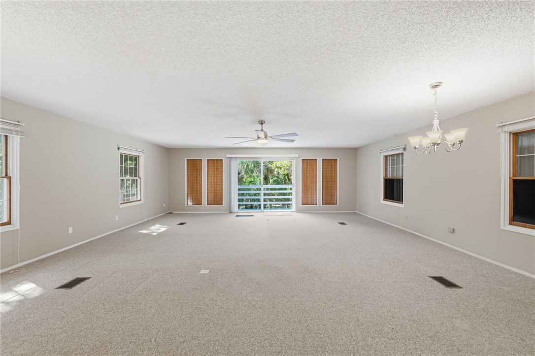 1951 West Shell Lane Vero Beach, FL 32963 - Photo 8 of 35 an empty room with a fireplace and large windows