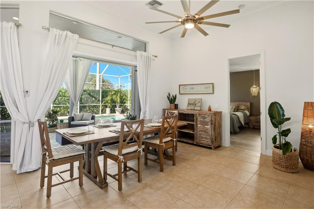 80 Delbrook Way Marco Island, FL 34145 - Photo 13 of 49 Dining room with a ceiling fan, a sunroom, light tile patterned floors, and crown molding