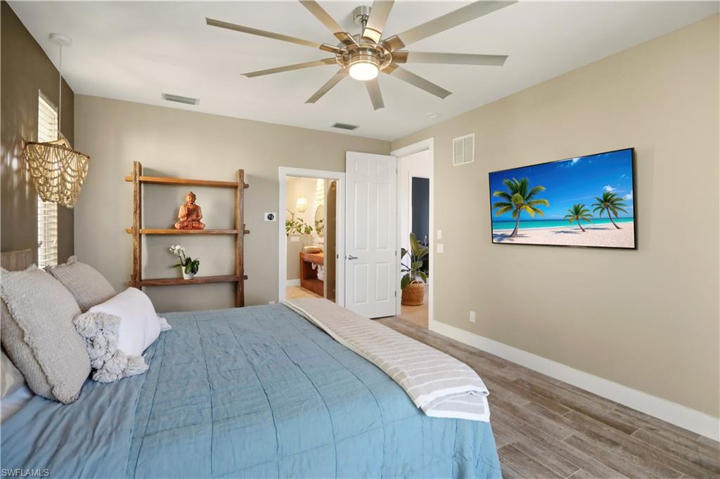 80 Delbrook Way Marco Island, FL 34145 - Photo 17 of 49 Bedroom with wood finish floors, ceiling fan, and ensuite bathroom