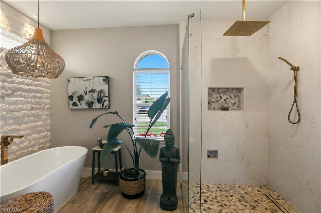 80 Delbrook Way Marco Island, FL 34145 - Photo 20 of 49 Full bathroom with a stall shower, a freestanding tub, and wood finished floors