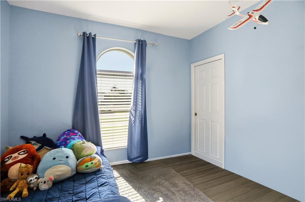 80 Delbrook Way Marco Island, FL 34145 - Photo 29 of 49 Unfurnished bedroom with wood finished floors and baseboards