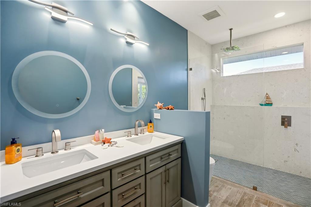 80 Delbrook Way Marco Island, FL 34145 - Photo 31 of 49 Bathroom featuring a walk in shower, double vanity, and light wood-style flooring