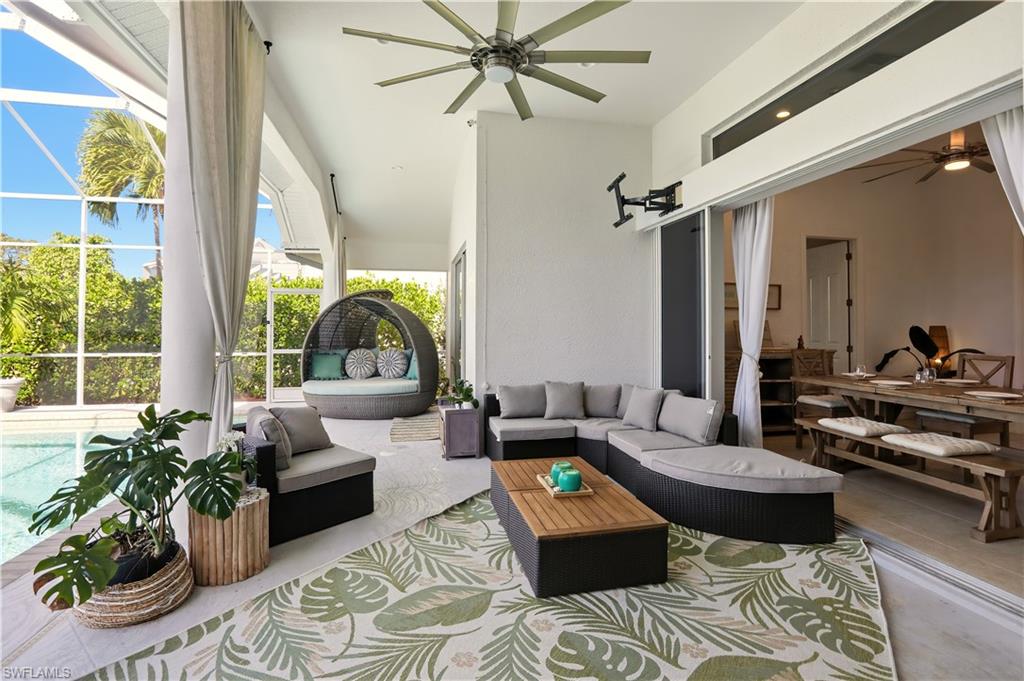 80 Delbrook Way Marco Island, FL 34145 - Photo 41 of 49 View of patio / terrace featuring a ceiling fan, glass enclosure, a sunroom, outdoor lounge area, and an outdoor pool