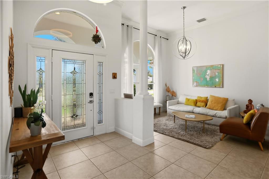 80 Delbrook Way Marco Island, FL 34145 - Photo 5 of 49 Foyer with ornate columns, light tile patterned floors, healthy amount of natural light, and ornamental molding