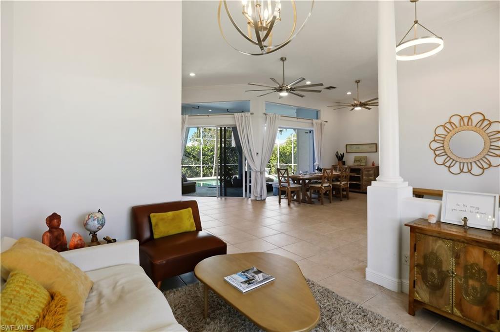 80 Delbrook Way Marco Island, FL 34145 - Photo 7 of 49 Living area with light tile patterned flooring, a ceiling fan, ornate columns, a chandelier, and recessed lighting
