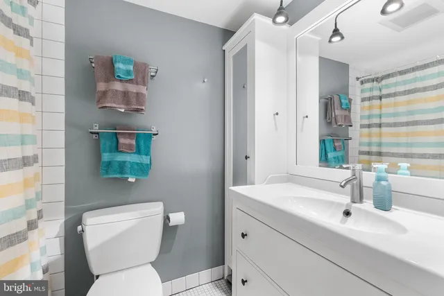 a bathroom with a toilet sink and mirror