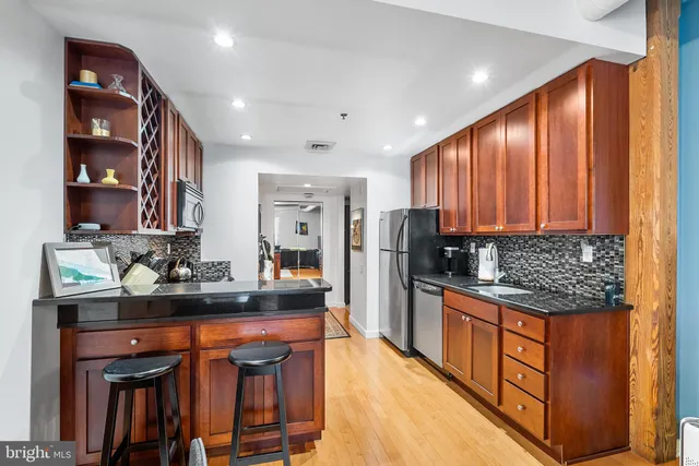 a kitchen with stainless steel appliances granite countertop a refrigerator and a stove top oven