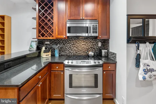 a kitchen with stainless steel appliances granite countertop a stove and a microwave