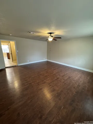 a view of an empty room with wooden floor