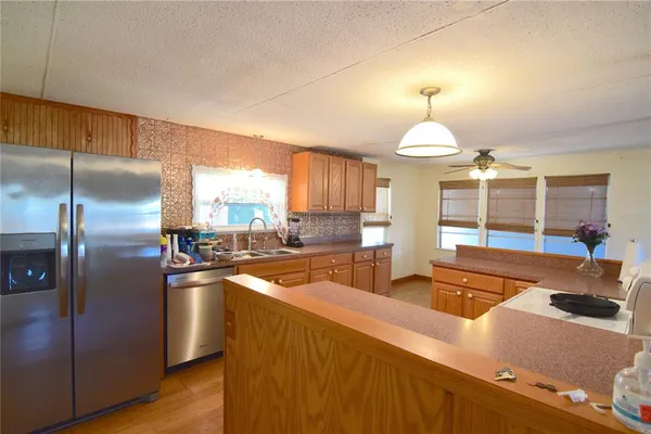 a kitchen with stainless steel appliances granite countertop a sink and a refrigerator