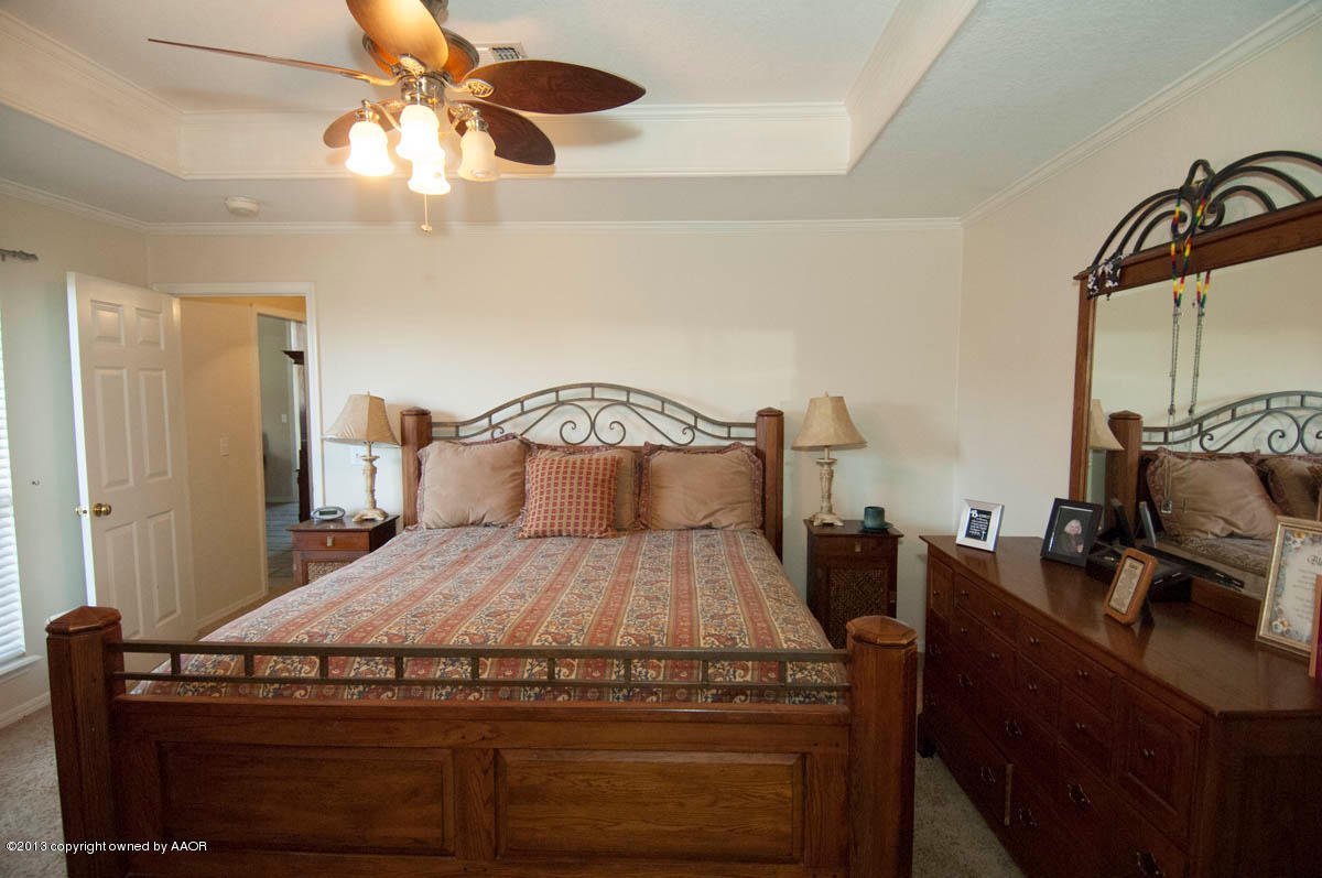 5402 Leo Lane Amarillo, TX 79110 - Photo 16 of 37 a bedroom with a bed and a chandelier