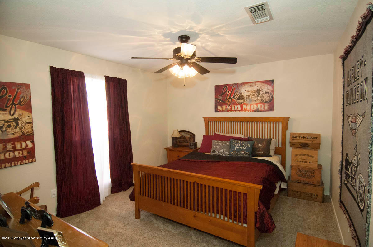 5402 Leo Lane Amarillo, TX 79110 - Photo 26 of 37 a bedroom with a bed and a chandelier